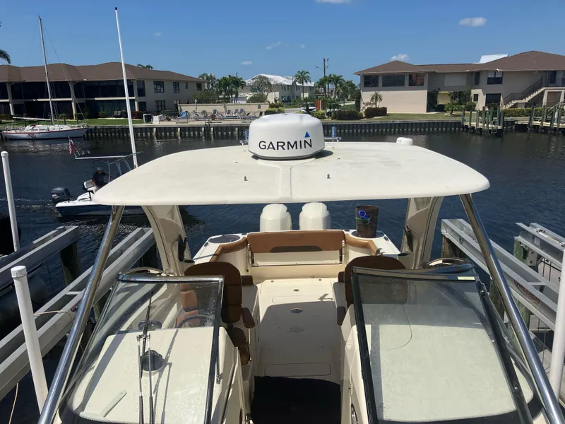 Slide: The Image of 2015 Scout 275 Dorado boat docked, featuring Garmin equipment, in a residential waterfront setting. - 5