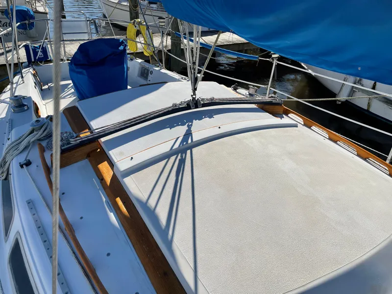 Slide: The Image of 1982 Catalina 30 sailboat deck with blue sail cover, docked at marina. - 13