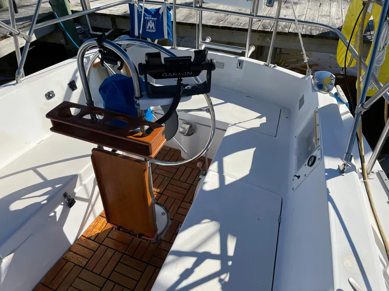 Slide: The Image of Cockpit of a 1982 Catalina 30 sailboat with wooden flooring and steering wheel. - 15