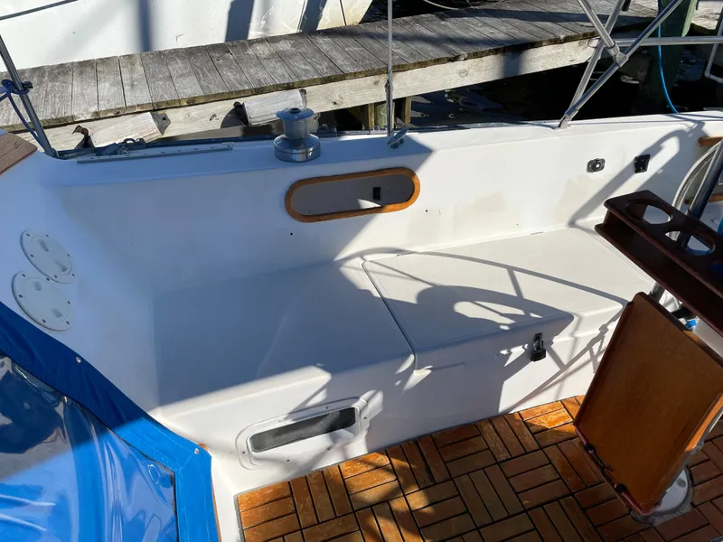 Slide: The Image of Cockpit of 1982 Catalina 30 sailboat with wooden flooring and seating area. - 16