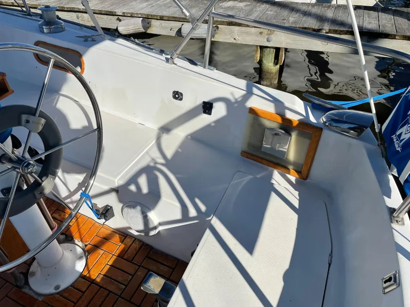 Slide: The Image of Cockpit of 1982 Catalina 30 sailboat with steering wheel and wooden flooring. - 17