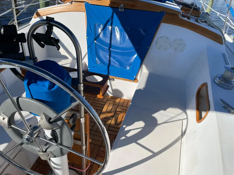 Slide: The Image of 1982 Catalina 30 sailboat cockpit with wooden flooring and blue seat cover. - 19