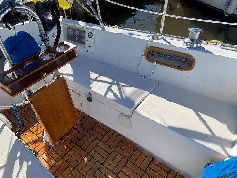 Slide: The Image of Cockpit of 1982 Catalina 30 sailboat with wooden flooring and seating area. - 22