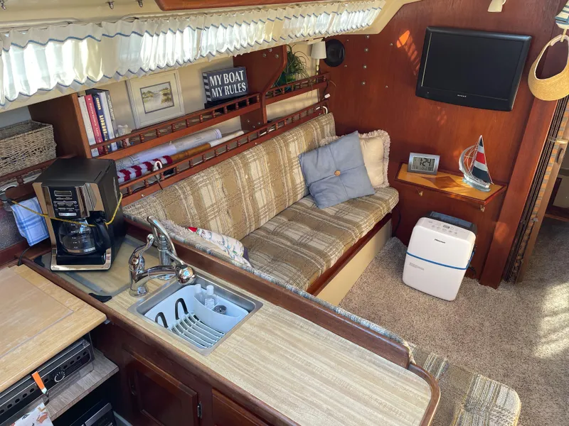 Slide: The Image of Interior of 1982 Catalina 30 sailboat with cozy seating, kitchenette, and decor. - 24
