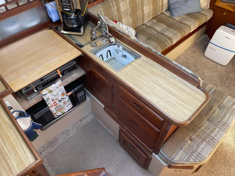 Slide: The Image of Interior of a 1982 Catalina 30 sailboat with compact kitchen and seating area. - 25