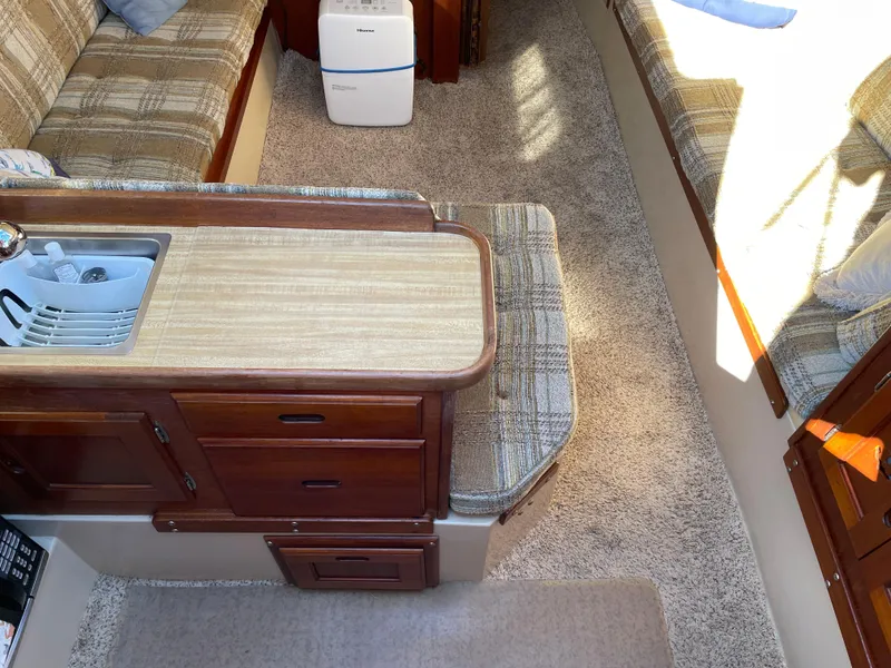 Slide: The Image of Interior of a 1982 Catalina 30 sailboat with cozy seating and compact kitchen area. - 27