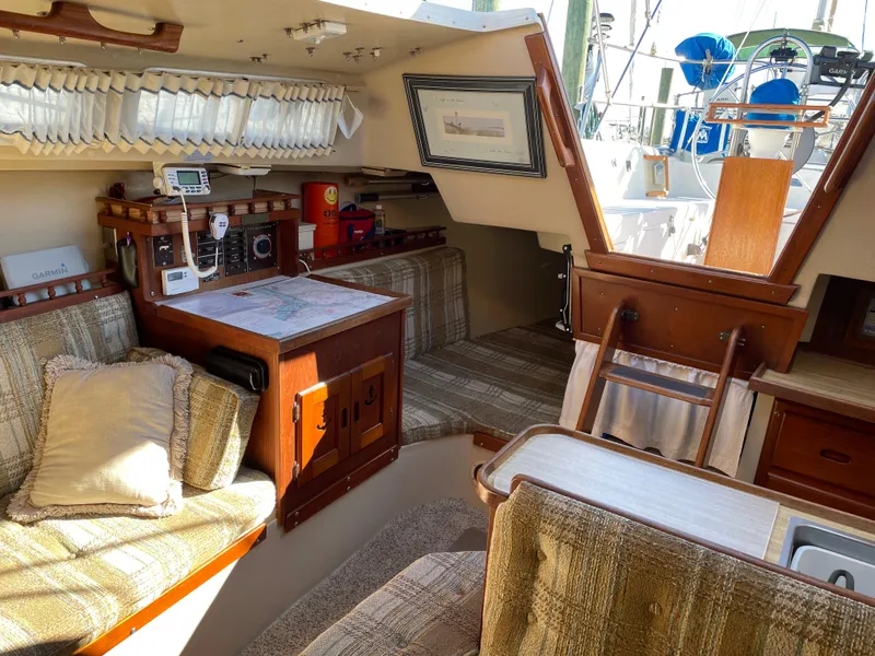 Slide: The Image of Interior of a 1982 Catalina 30 sailboat with cozy seating and navigation equipment. - 31