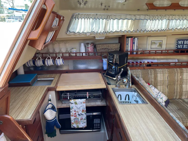 Slide: The Image of Cozy 1982 Catalina 30 yacht kitchen with wooden cabinetry, sink, and coffee maker. - 36