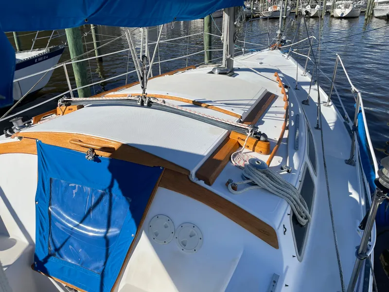 Slide: The Image of 1982 Catalina 30 sailboat deck with blue canvas, docked in marina. - 5