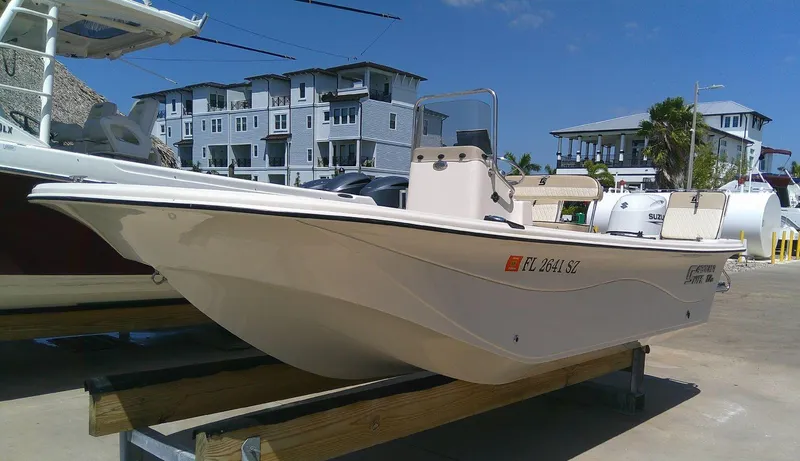 Slide: The Image of 2021 Carolina Skiff 17 LS boat on display, with modern buildings in the background. - 1
