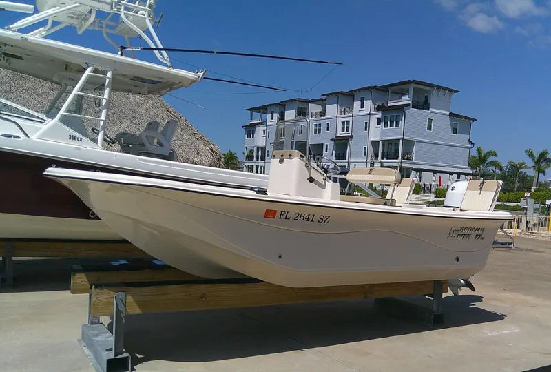 Slide: The Image of 2021 Carolina Skiff 17 LS boat on display, docked near modern buildings. - 10