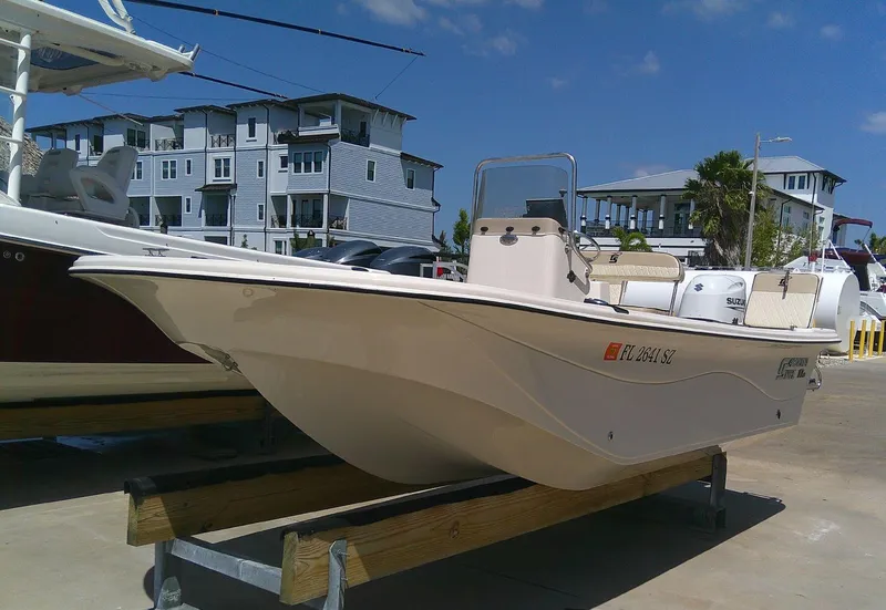 Slide: The Image of 2021 Carolina Skiff 17 LS boat on display, docked near modern waterfront buildings. - 18