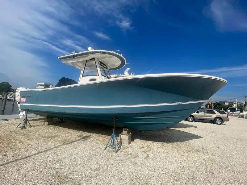 Slide: The Image of 2022 Regulator 31 boat on display, blue hull, clear sky background. - 0