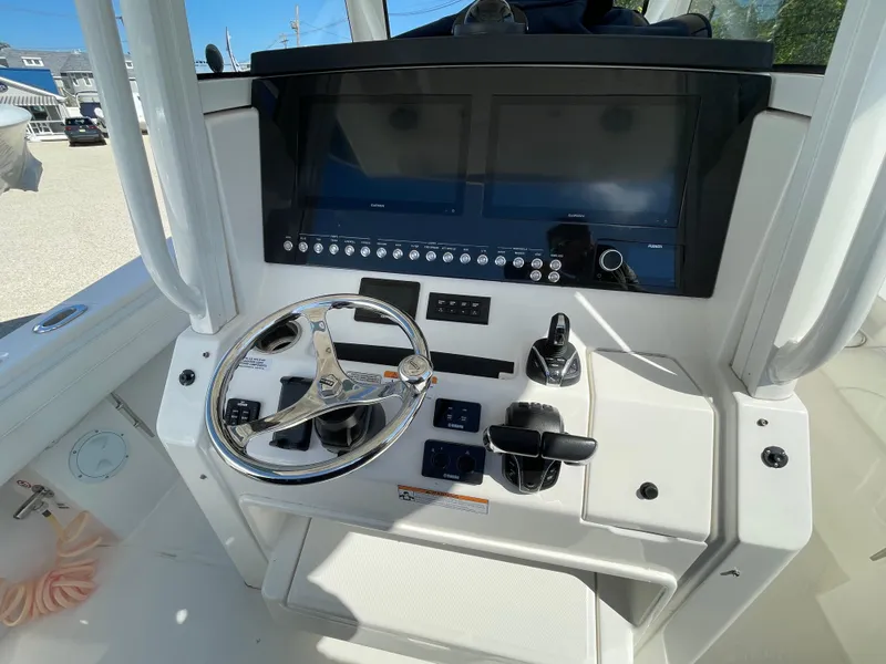 Slide: The Image of 2022 Regulator 31 boat helm with steering wheel and control panel. - 13