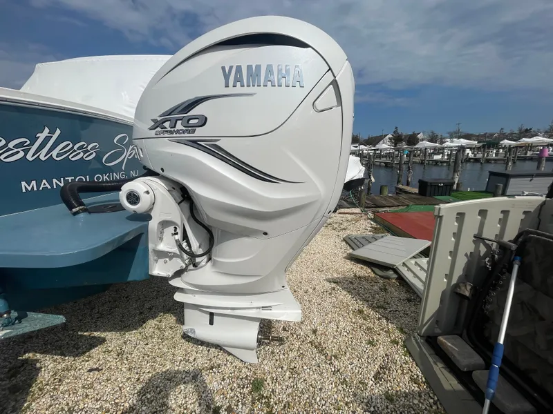 Slide: The Image of Yamaha XTO outboard motor on a 2022 Regulator 31 boat, docked on gravel. - 36