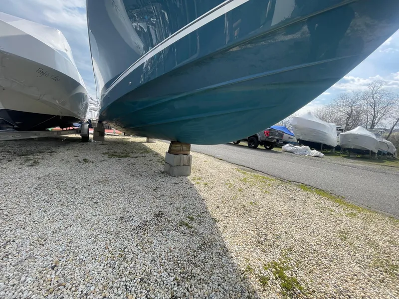 Slide: The Image of 2022 Regulator 31 boat on blocks, displayed outdoors on gravel. - 5