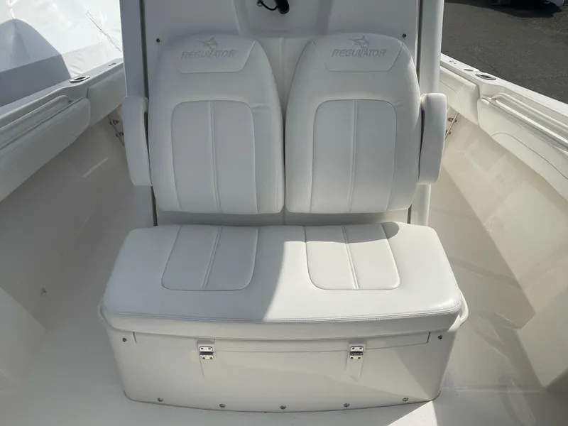 Slide: The Image of 2022 Regulator 31 boat with white cushioned seating and storage compartment. - 8