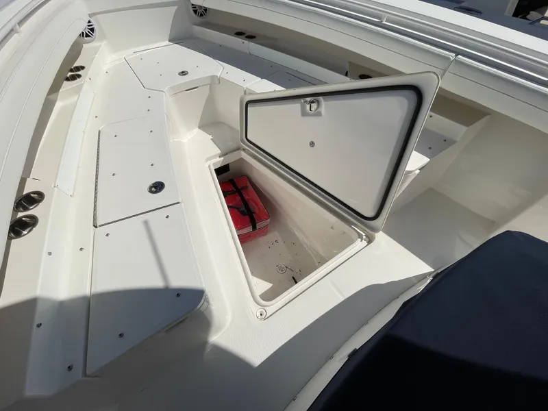 Slide: The Image of 2022 Regulator 31 boat with open storage compartment, revealing a red item inside. - 9
