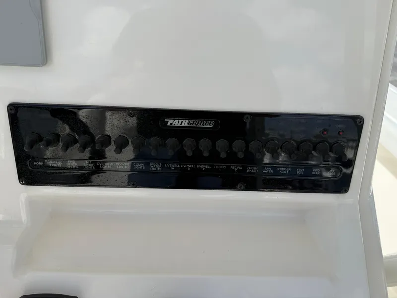 Slide: The Image of Control panel of 2023 Pathfinder 2400 Open boat with multiple switches and labels. - 13