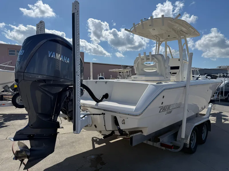 Slide: The Image of 2023 Pathfinder 2400 Open boat with Yamaha engine, parked on a trailer under a sunny sky. - 2