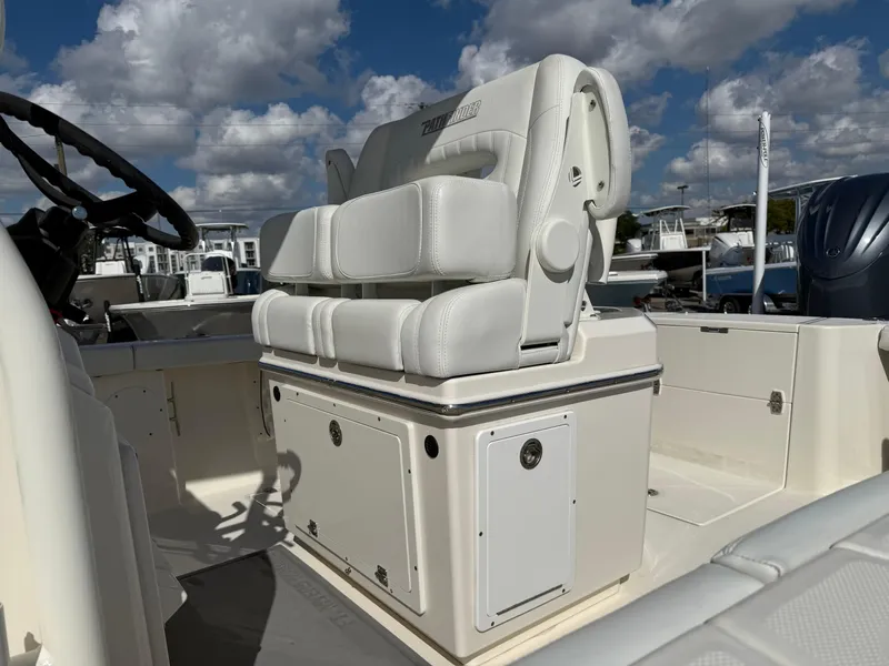 Slide: The Image of 2023 Pathfinder 2400 Open boat interior with cushioned seating and steering wheel under a cloudy sky. - 4