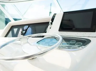 Slide: The Image of Steering wheel and dashboard of a 1999 Viking Express boat, featuring modern controls. - 13