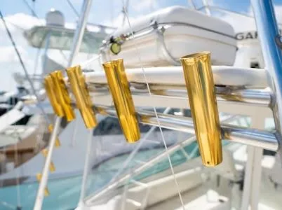 Slide: The Image of Gold rod holders on a 1999 Viking Express boat, with a clear sky background. - 25