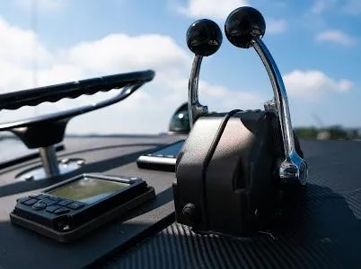 Slide: The Image of Control panel of a 1999 Viking Express boat with throttle levers and navigation equipment. - 28