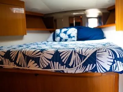 Slide: The Image of 1999 Viking Express cabin with a cozy bed, featuring blue and white leaf-patterned bedding. - 5