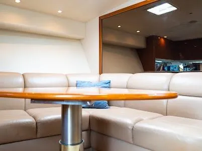 Slide: The Image of Luxurious interior of 1999 Viking Express yacht with beige leather seating and wooden table. - 7