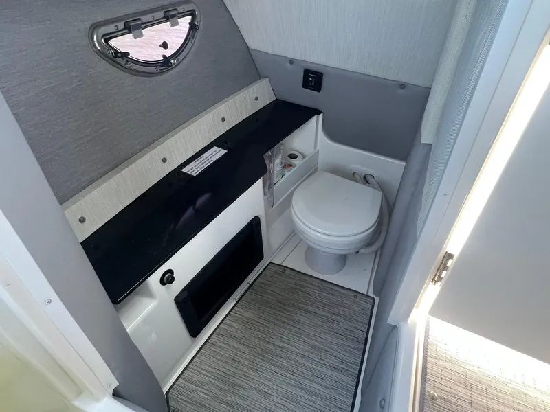 Slide: The Image of 2022 Cobalt R8 Outboard boat interior bathroom with toilet and window. - 18