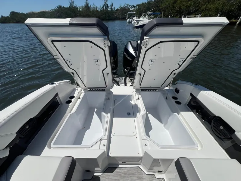 Slide: The Image of 2022 Cobalt R8 Outboard boat with open storage compartments on a calm lake. - 29