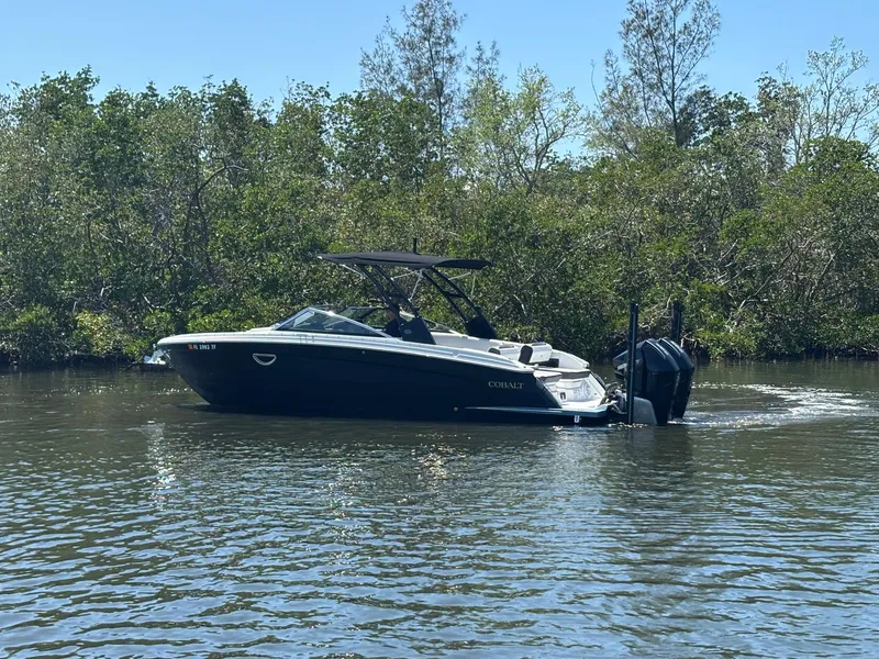 Slide: The Image of 2022 Cobalt R8 Outboard boat cruising on a calm river with lush greenery. - 4