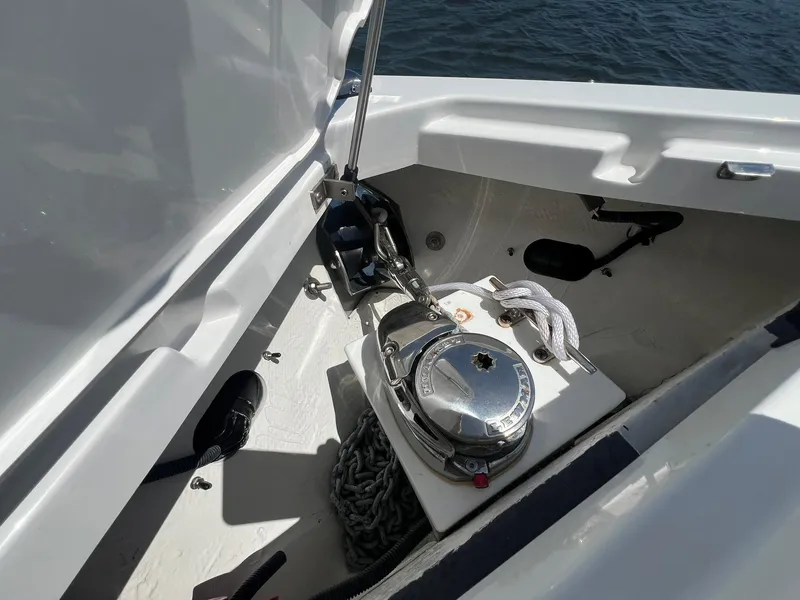 Slide: The Image of 2022 Cobalt R8 Outboard anchor compartment with chain and rope on a sunny day. - 7
