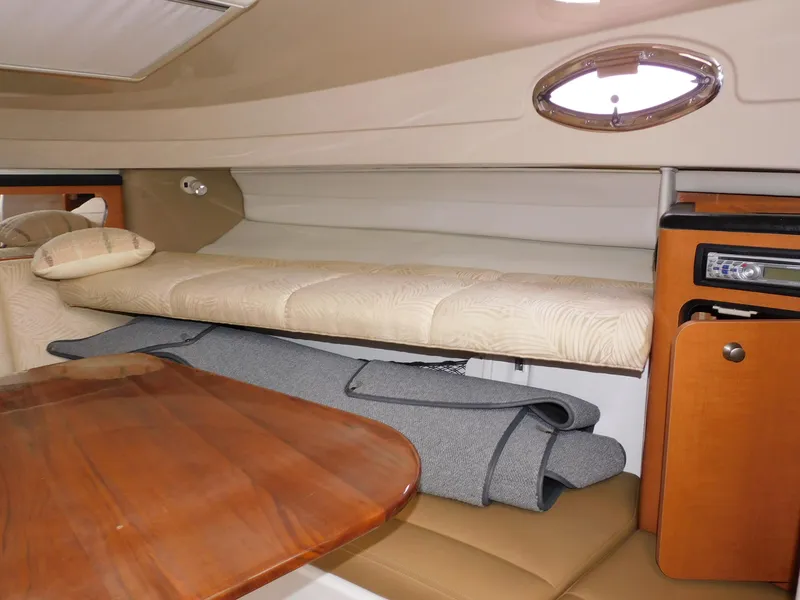 Slide: The Image of 2008 Robalo R305 Walkaround cabin interior with wooden table and cushioned seating. - 19