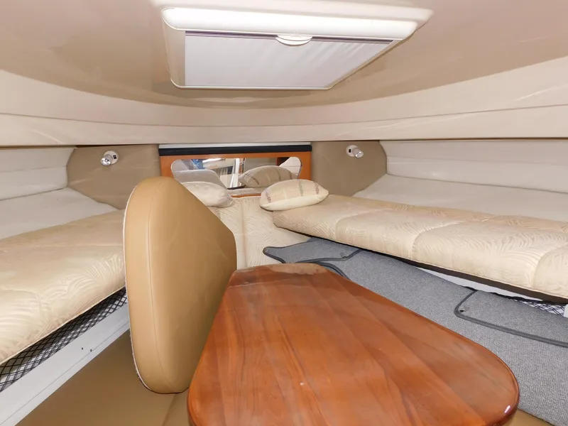 Slide: The Image of 2008 Robalo R305 Walkaround cabin interior with beige seating and wooden table. - 20