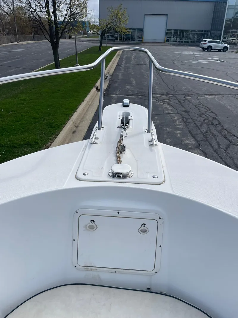 Slide: The Image of Edgewater 220CC 2000 boat bow with anchor chain and railing in a parking lot. - 10