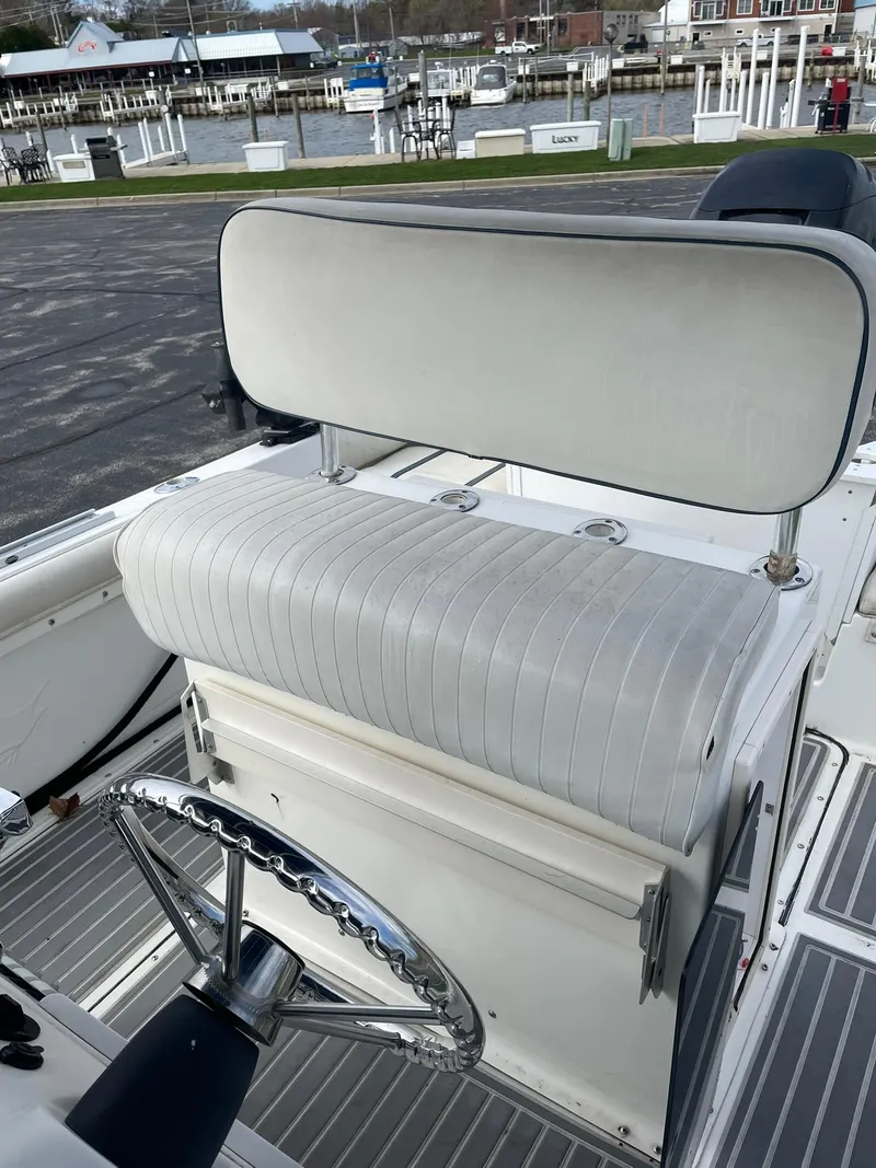 Slide: The Image of Edgewater 220CC 2000 boat interior with cushioned seating and steering wheel. - 17