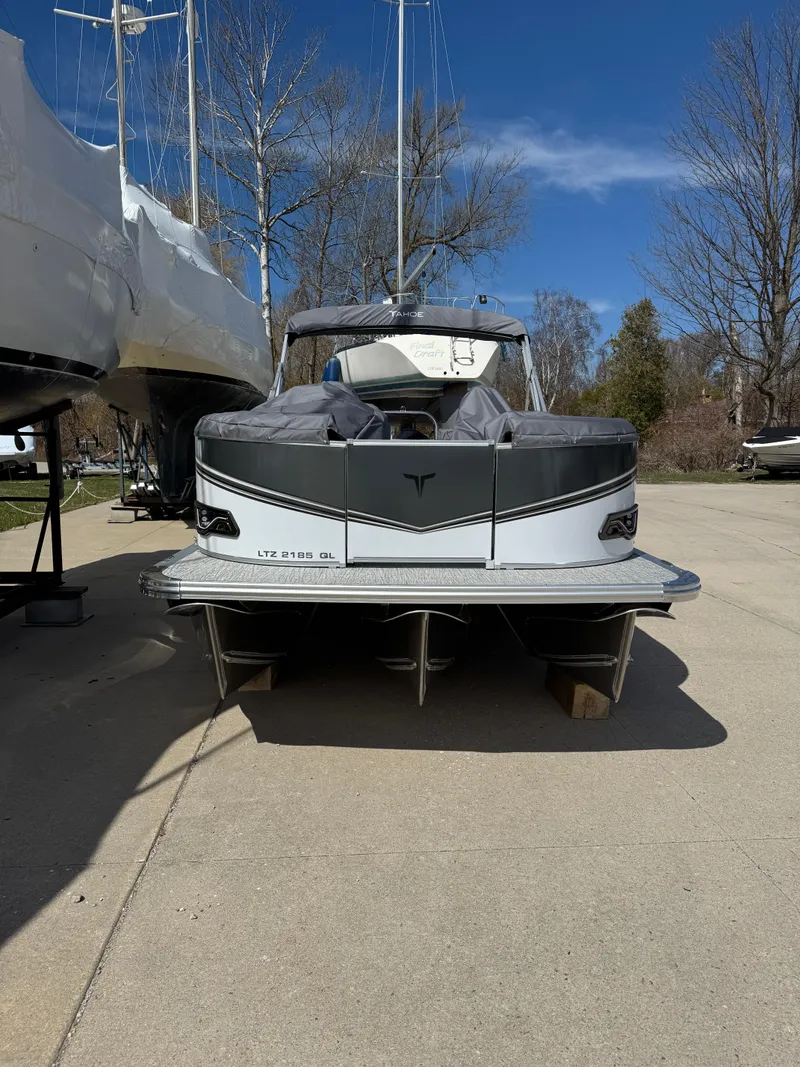 Slide: The Image of 2025 Tahoe Pontoon LTZ Quad Lounger on a sunny day, parked on concrete. - 1