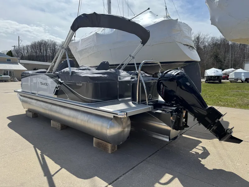 Slide: The Image of 2025 Tahoe Pontoon LTZ Quad Lounger with outboard motor on display outdoors. - 4