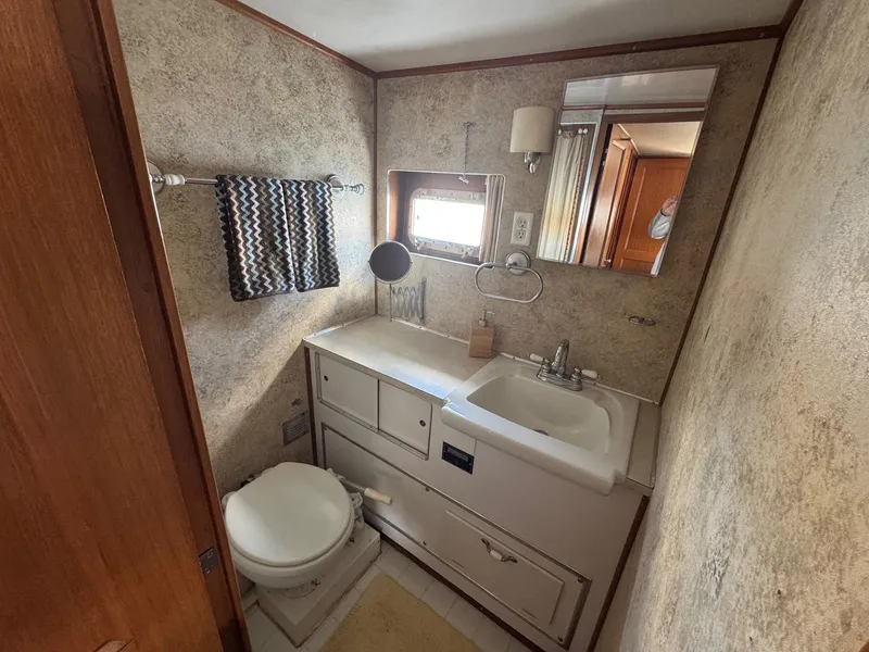 Slide: The Image of 1968 Hatteras 38 Double Cabin bathroom with sink, toilet, and window. - 10