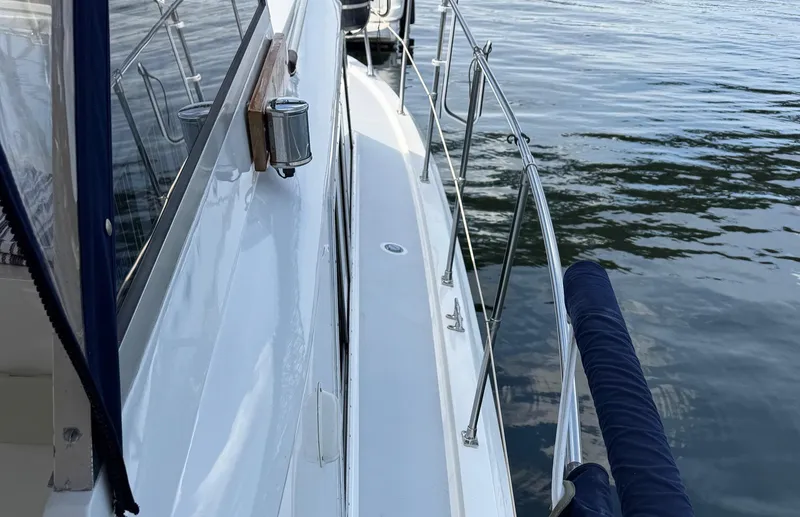 Slide: The Image of 1968 Hatteras 38 Double Cabin yacht deck with railing, docked on calm water. - 17