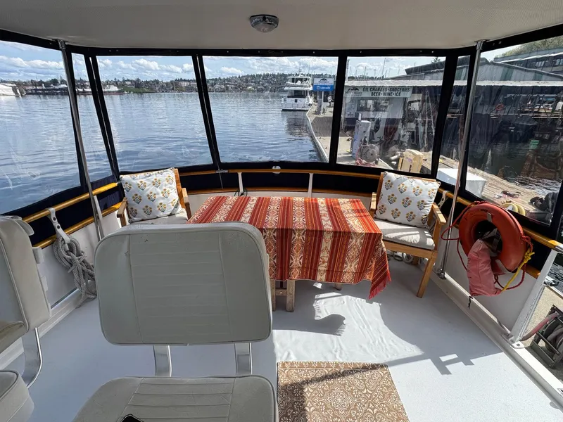 Slide: The Image of 1968 Hatteras 38 Double Cabin interior with table, chairs, and waterfront view. - 21