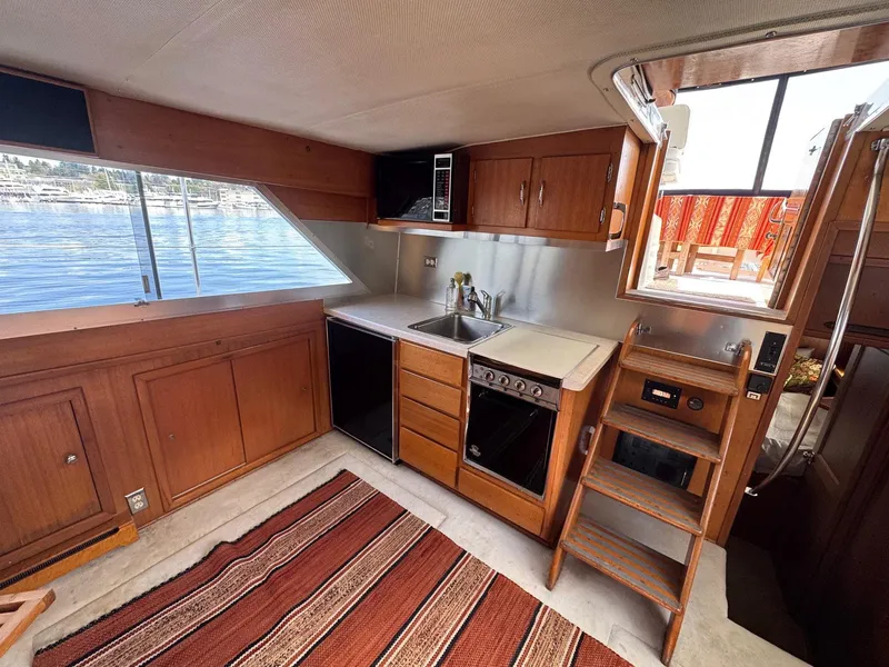Slide: The Image of 1968 Hatteras 38 Double Cabin kitchen with wood cabinetry, stove, and sink, overlooking water. - 4