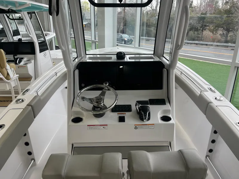 Slide: The Image of 2025 Sportsman Heritage 231 Center Console boat interior with steering wheel and controls. - 14