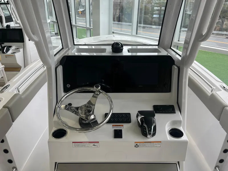 Slide: The Image of 2025 Sportsman Heritage 231 Center Console boat dashboard with steering wheel and controls. - 4