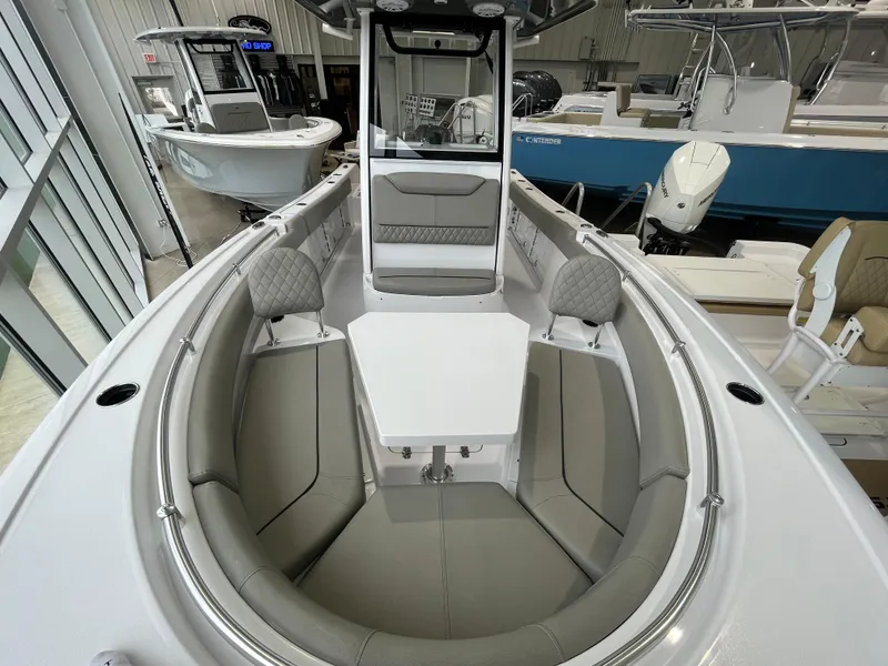 Slide: The Image of 2025 Sportsman Heritage 231 Center Console boat interior with cushioned seating and table. - 9