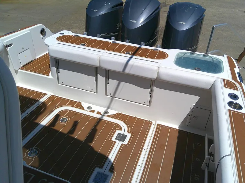 Slide: The Image of 2009 Everglades 350LX boat deck with wood finish and triple outboard motors. - 14