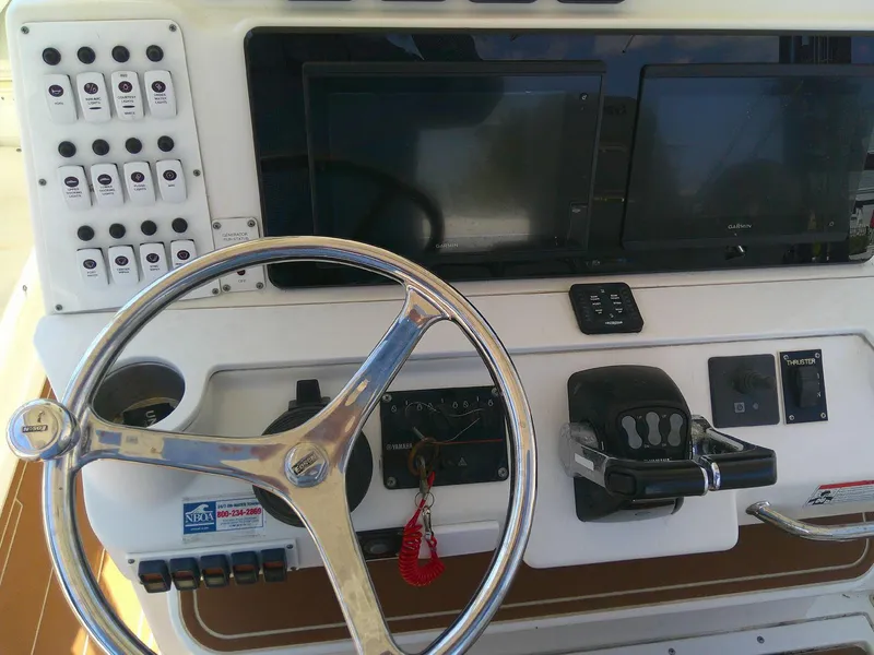 Slide: The Image of Control panel of a 2009 Everglades 350LX boat with steering wheel and navigation equipment. - 16
