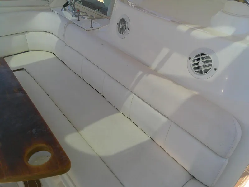 Slide: The Image of White seating area on 2009 Everglades 350LX boat with wooden table and built-in speakers. - 17